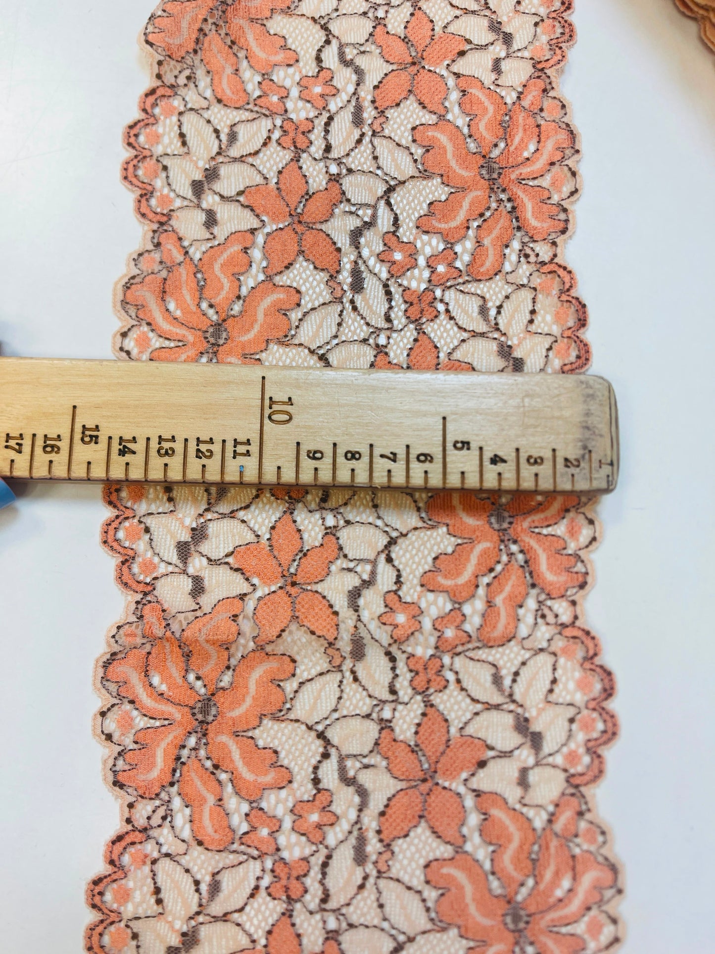 Kuva joustavasta 14 cm pitsistä, oranssit kukat ja beige pohja – saatavilla verkossa Šarlotes audumi