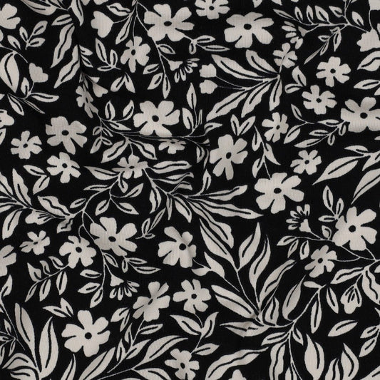 Image with cotton knit fabric - white flowers on black 200 g/m² – available at Charlote's Fabrics