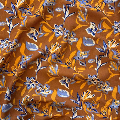 Tissu 100 % viscose - motif floral abstrait sur fond orange 125 g/m²