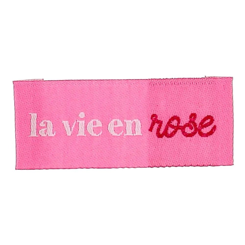 Kuva Bohin-ommeltavasta vaate-etiketistä ”La vie en rose” – katsoa elämää ruusunpunaisten lasien läpi – 2 × 5 cm, 4 kpl – saatavilla verkossa Šarlotes audumi