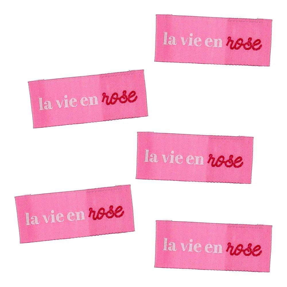 Kuva Bohin-ommeltavasta vaate-etiketistä ”La vie en rose” – katsoa elämää ruusunpunaisten lasien läpi – 2 × 5 cm, 4 kpl – saatavilla verkossa Šarlotes audumi