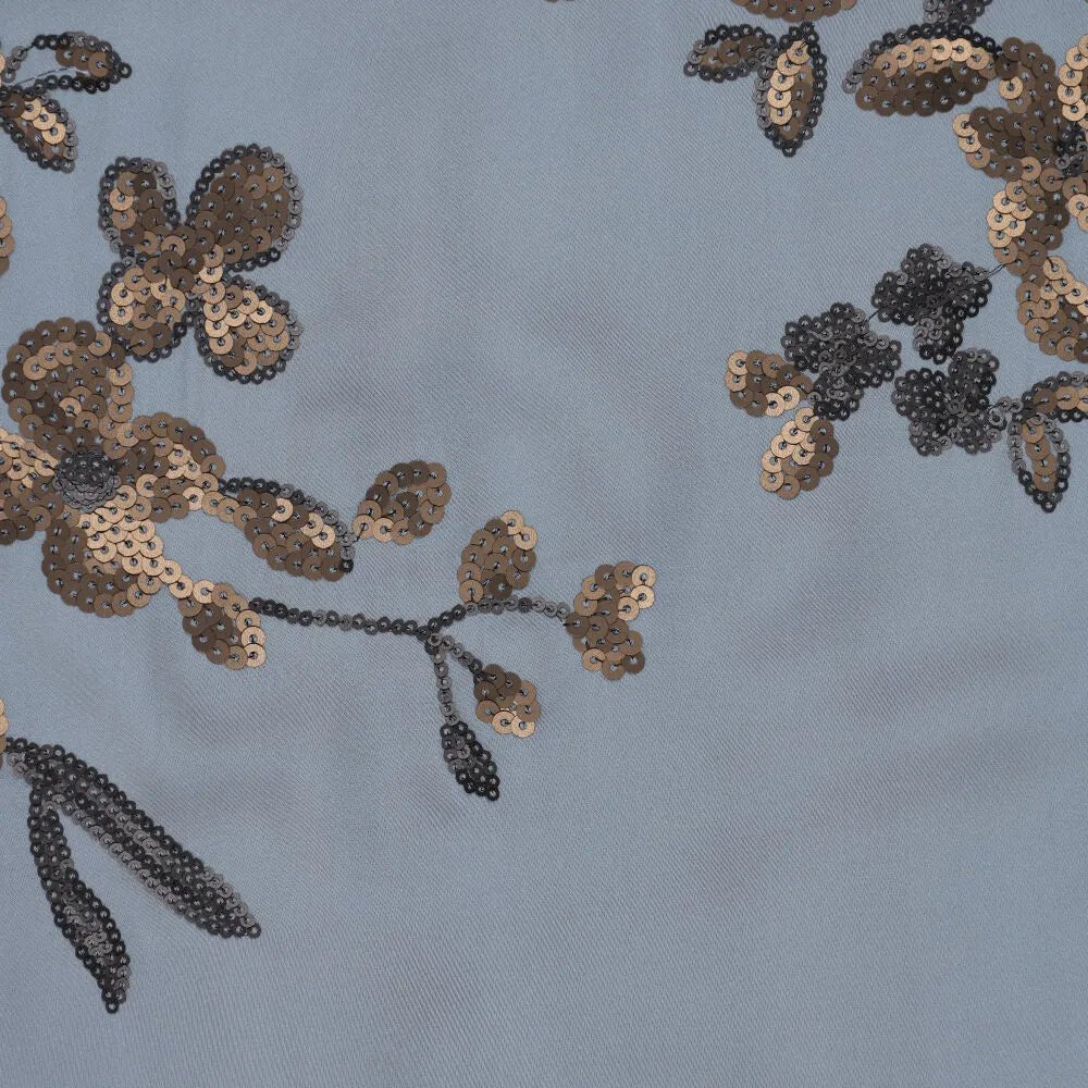 Image of stretchy satin fabric with floral embroidery and sequins in blue, black and gold – available online at Charlotte's Fabrics