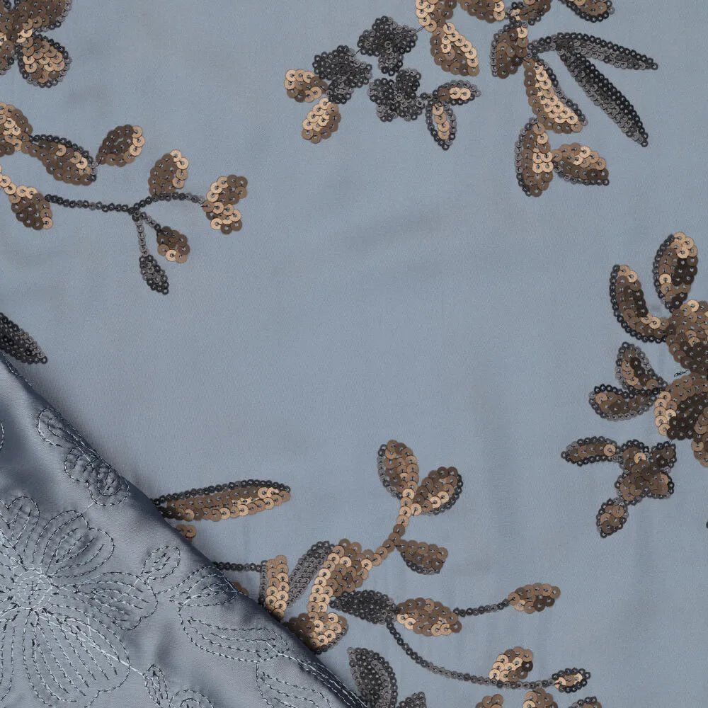 Image of stretch satin fabric with floral embroidery and sequins in blue, black and gold – available online at Šarlotes audumi