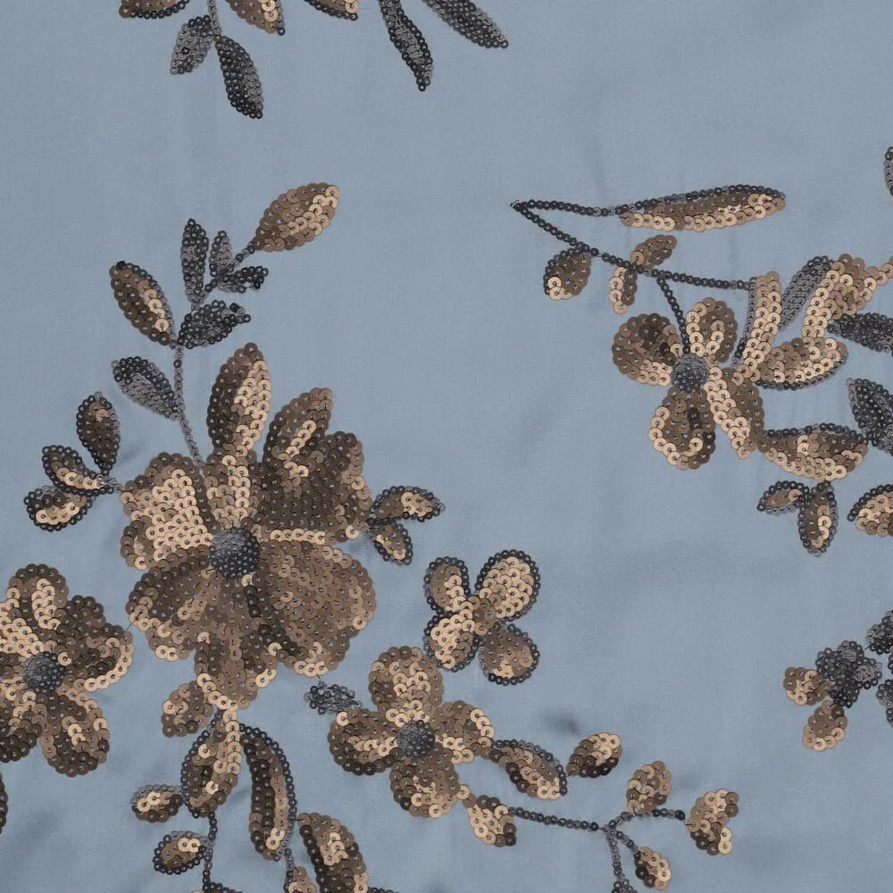 Image of flexible satin fabric with floral embroidery and sequins in blue, black and gold, available online at Šarlotes audumi