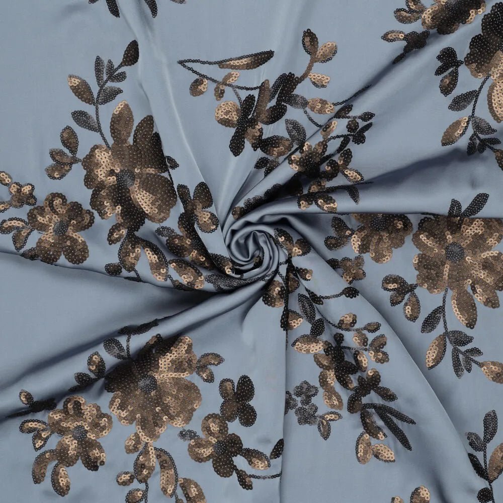 alt
Image of flexible satin fabric with floral embroidery and sequins in blue, black, and gold – available online at Šarlotes audumi