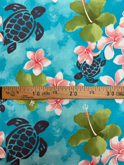 Image of French fabric with a tropical floral pattern in blue-green tones – available online at Charlotte's Fabrics