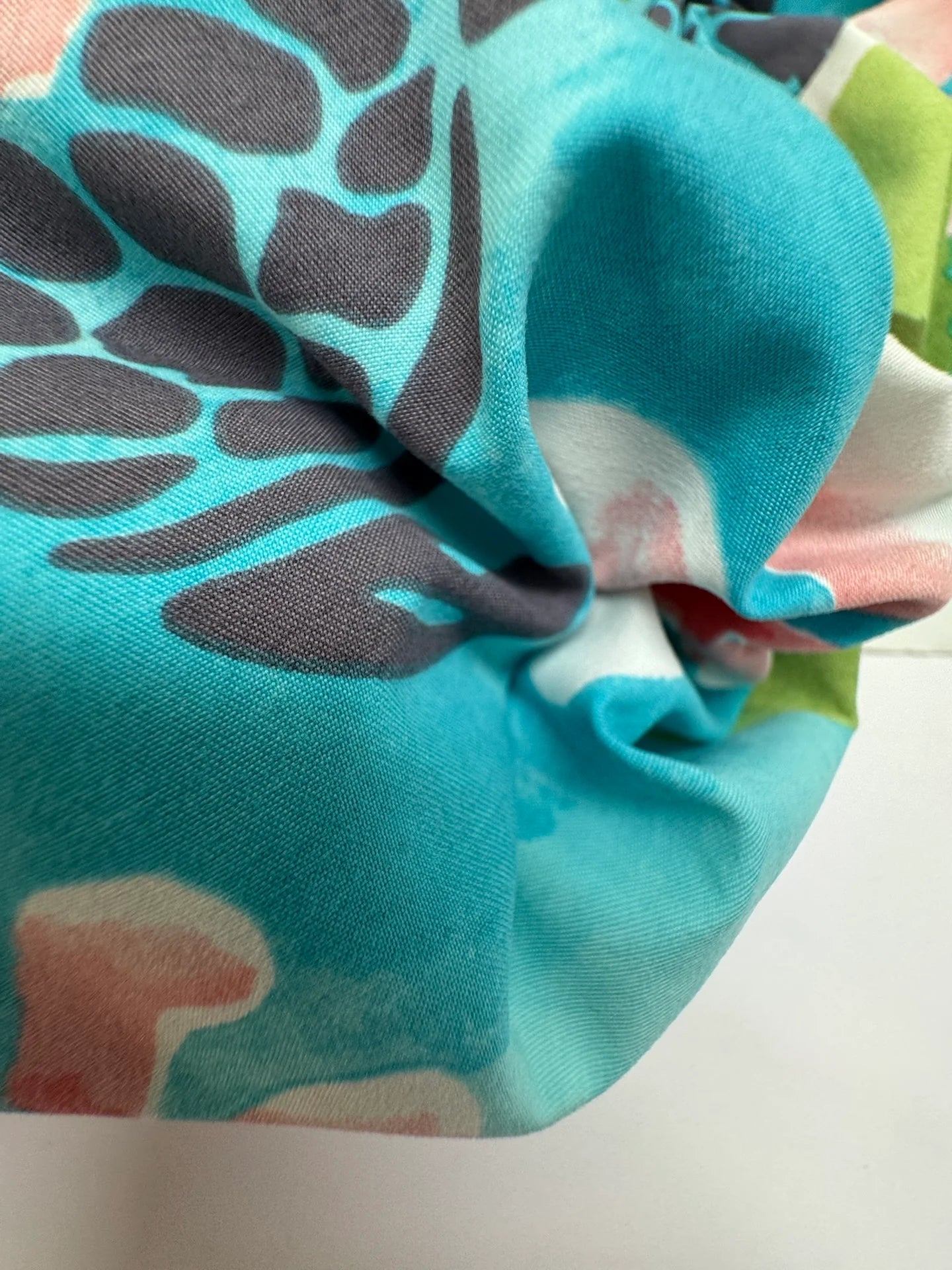 Image of French fabric with a tropical floral pattern in teal tones – available online at Charlotte's Fabrics