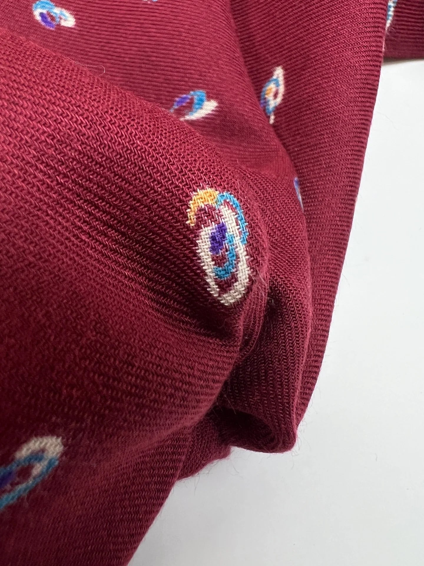 Image of Italian twill fabric in burgundy with a subtle pattern – available online at Šarlotes audumi