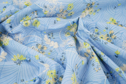 Image de tissu en coton brodé - fleurs jaunes sur fond bleu 115 g/m² – disponible chez Šarlotes audumi