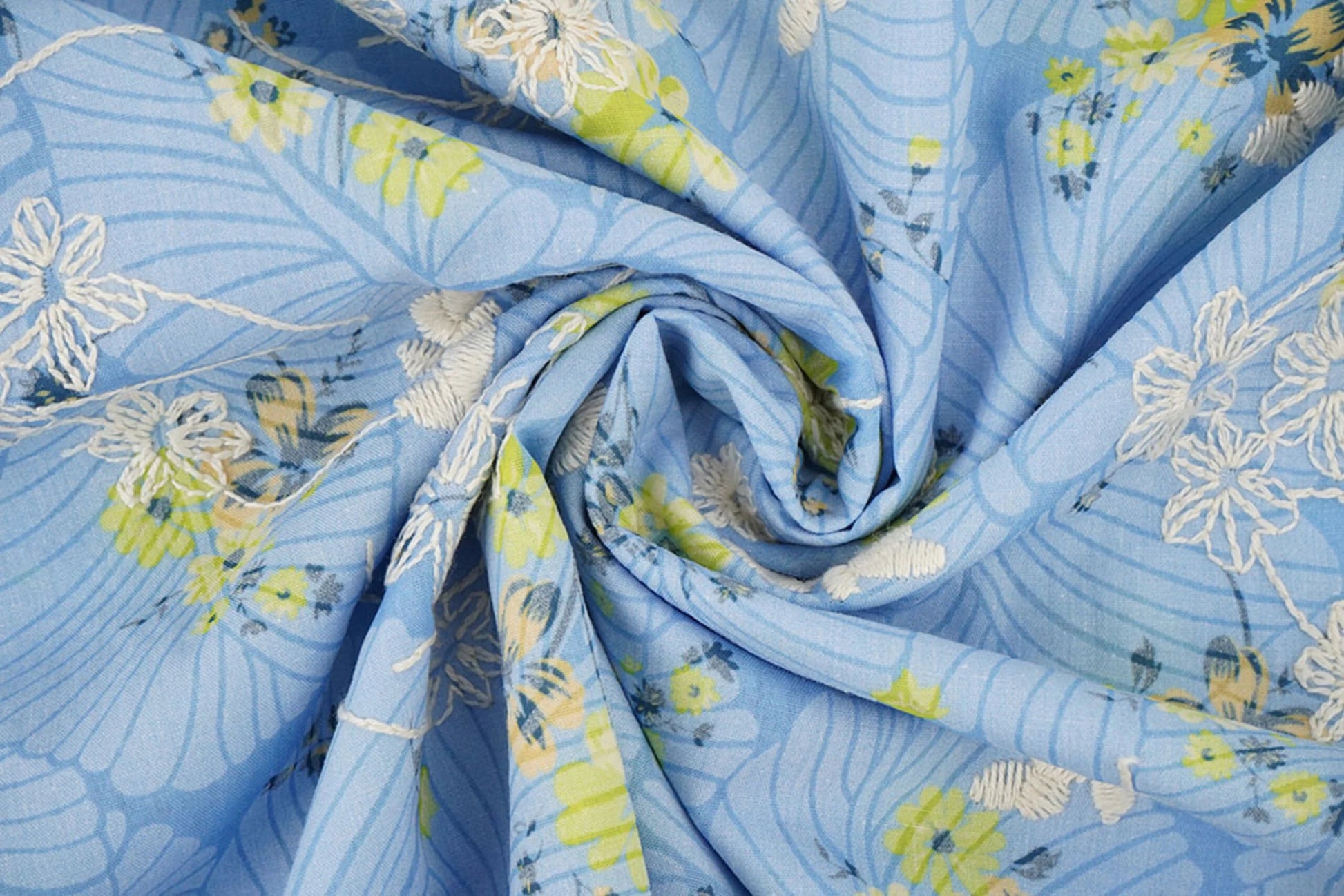 Image d’un tissu en coton brodé - fleurs jaunes sur fond bleu 115 g/m² – disponible chez Šarlotes audumi