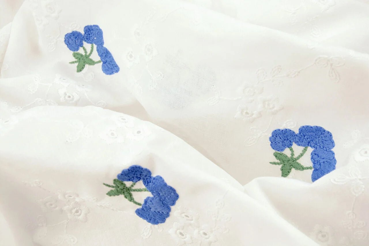 Tissu de coton brodé - fleurs bleues 110 g/m²