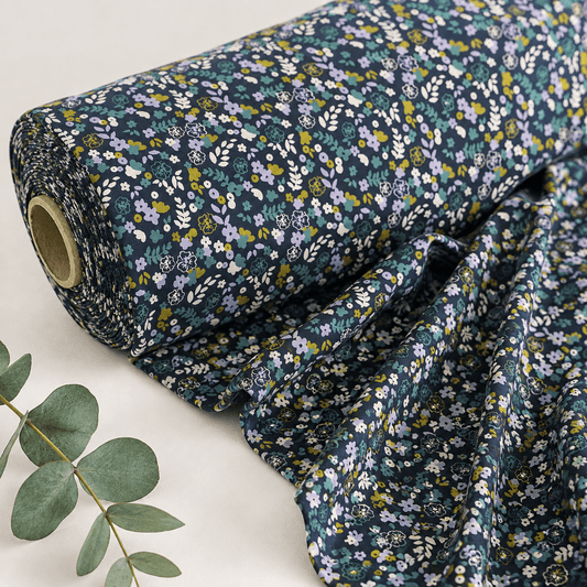 Image of cotton jersey with delicate flowers on a dark blue background – available online at Charlotte’s Fabrics