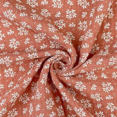 Mousseline - fleurs blanches sur fond orange 130 g/m²