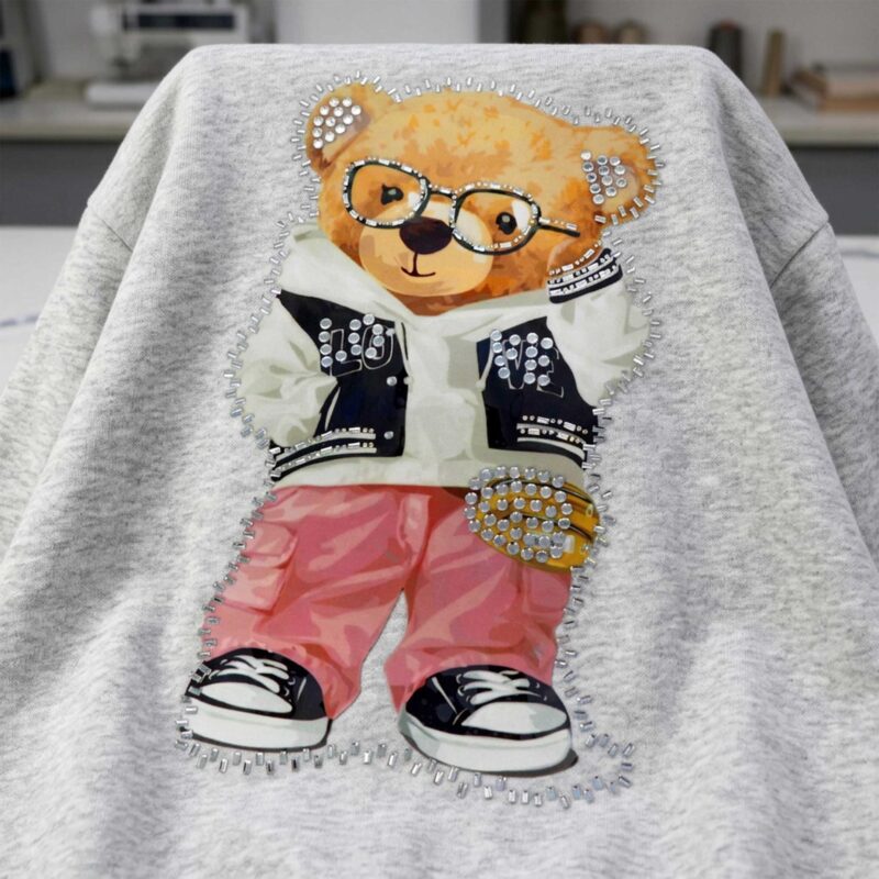 Kuva termoapplikaatiosta “Nalle laseilla” – 29 × 17 cm – saatavilla verkossa Šarlotes audumi